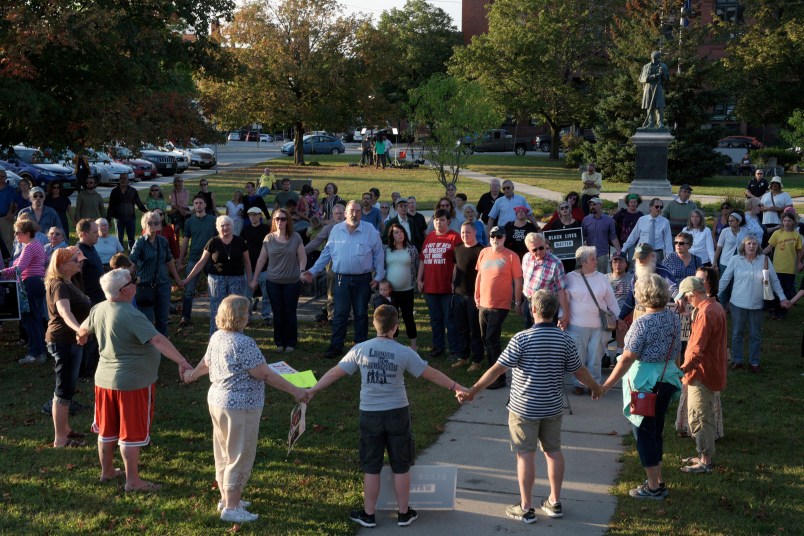 A chorus of "We Shall Overcome" rises from a gathering against racism in Broad Street Park in Claremont, N.H., Tuesday, September 12, 2017. The demonstration was inspired by violence last month against an 8-year-old biracial boy that occurred while he played with a group of teenagers outside his home. (AP Photo/Valley News, James M. Patterson)