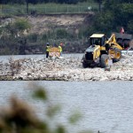 HOLD FOR STORY BY MICHAEL BIESECKER--Workers are shown at San Jacinto River Waste Pits near the Interstate 10 bridge over the river Wednesday, Sept. 13, 2017, in Channelview, Texas. (AP Photo/David J. Phillip)
