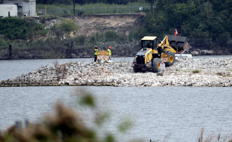 HOLD FOR STORY BY MICHAEL BIESECKER--Workers are shown at San Jacinto River Waste Pits near the Interstate 10 bridge over the river Wednesday, Sept. 13, 2017, in Channelview, Texas. (AP Photo/David J. Phillip)