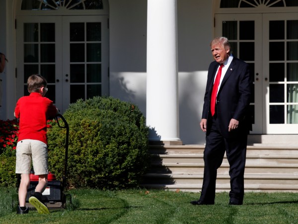 Frank "FX" Giaccio, 11, of Falls Church, Va., is surprised by President Donald Trump, Friday, Sept. 15, 2017, as he mows the lawn of the Rose Garden at the White House in Washington. The 11-year-old was focused on the job at hand and didn't notice the president until he was right next to him. (AP Photo/Jacquelyn Martin)
