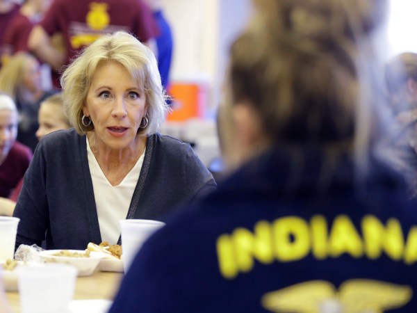 U.S. Secretary of Education Betsy DeVos talks with Gracie Johnsonduring a hog roast before a high school football game between Eastern Hancock and Knightstown, Friday, Sept. 15, 2017, in Charlottesville, Ind. (AP Photo/Darron Cummings)