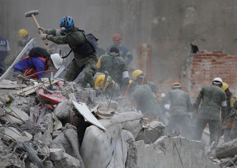 at a building that collapsed after an earthquake in Mexico City, Mexico, Thursday, Sept. 21, 2017.Tuesday's magnitude 7.1 earthquake has stunned central Mexico, killing more than 200 people as buildings collapsed in plumes of dust.(AP Photo/Natacha Pisarenko)