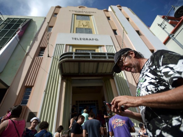 Ricardo Castellanos stablished communication thru his cellphone at a wifi hotspot located at Ponce de Leon avenue on the fourth day after the impact of Maria, a Category 5 hurricane that crossed the island, in San Juan, Puerto Rico, Sunday, September 24, 2017. Shortly after the passing of the hurricane all communications collapsed all over the US Territory. (AP Photo/Carlos Giusti)