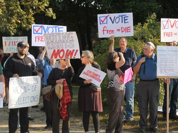 Protesters gather on Tuesday, Sept. 12, 2017, at Saint Anselm College in Manchester, New Hampshire, ahead of a  day-long meeting of the Trump administration’s election integrity commission. They argue the commission, which is tasked with investigating voter fraud, is a sham. Signs reading “Vote Free or Die” played off New Hampshire’s motto: “Live Free or Die.” (AP Photo/Holly Ramer).