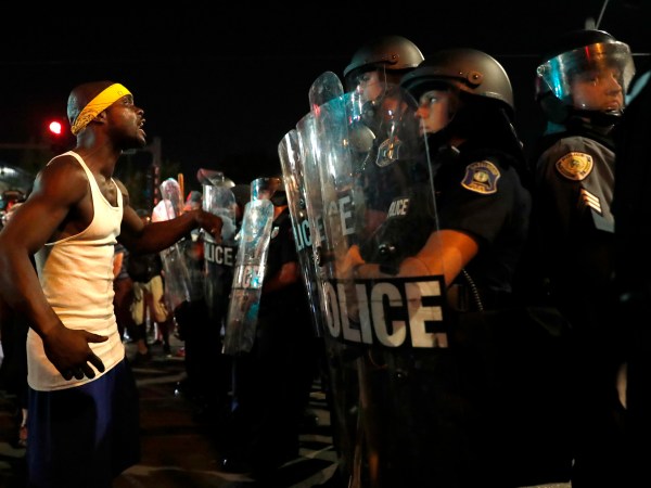 A man yells at police in riot gear just before a crowd turned violent Saturday, Sept. 16, 2017, in University City, Mo. Earlier, protesters marched peacefully in response to a not guilty verdict in the trial of former St. Louis police officer Jason Stockley . (AP Photo/Jeff Roberson)