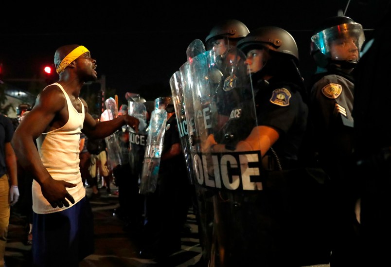 A man yells at police in riot gear just before a crowd turned violent Saturday, Sept. 16, 2017, in University City, Mo. Earlier, protesters marched peacefully in response to a not guilty verdict in the trial of former St. Louis police officer Jason Stockley . (AP Photo/Jeff Roberson)