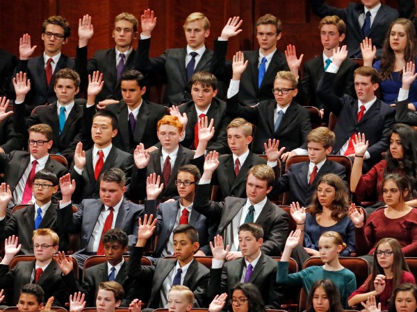 Members of a youth choir raise their hands during a sustaining vote during the afternoon session of the two-day Mormon church conference Saturday, Sept. 30, 2017, in Salt Lake City.  (AP Photo/Rick Bowmer)