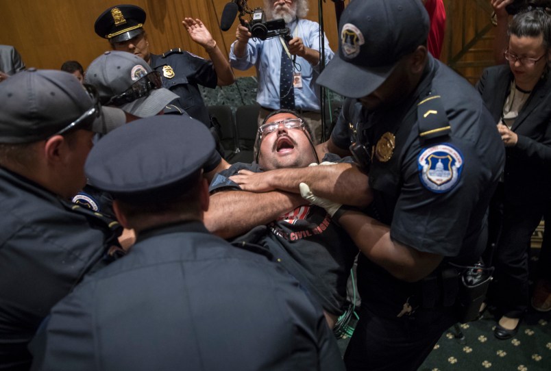 Activists opposed to the  GOP's Graham-Cassidy health care repeal bill, many with disabilities, are removed by U.S. Capitol Police after disrupting a Senate Finance Committee hearing on the last-ditch GOP push to overhaul the nation's health care system, on Capitol Hill in Washington, Monday, Sept. 25, 2017. (AP Photo/J. Scott Applewhite)