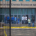 Staff stand within the United States embassy facility in Havana, Cuba, Friday, Sept. 29, 2017. The United States issued an ominous warning to Americans on Friday to stay away from Cuba and ordered home more than half the U.S. diplomatic corps, acknowledging neither the Cubans nor America’s FBI can figure out who or what is responsible for months of mysterious health ailments. (AP Photo/Desmond Boylan)