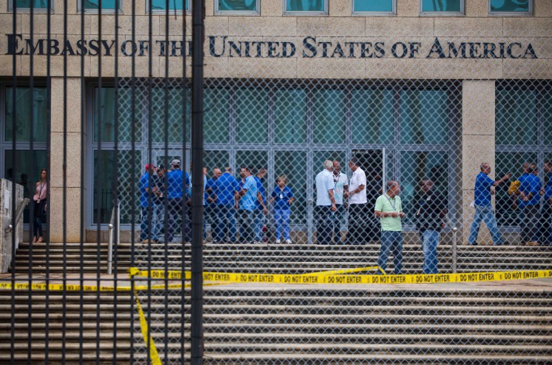 Staff stand within the United States embassy facility in Havana, Cuba, Friday, Sept. 29, 2017. The United States issued an ominous warning to Americans on Friday to stay away from Cuba and ordered home more than half the U.S. diplomatic corps, acknowledging neither the Cubans nor America’s FBI can figure out who or what is responsible for months of mysterious health ailments. (AP Photo/Desmond Boylan)