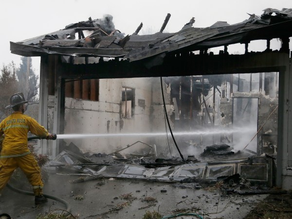 A Santa Rosa firefighter hoses down a hotspot in the Coffey Park area of Santa Rosa, Calif., on Tuesday, Oct. 10, 2017, An onslaught of wildfires across a wide swath of Northern California broke out almost simultaneously then grew exponentially, swallowing up properties from wineries to trailer parks and tearing through both tiny rural towns and urban subdivisions. (AP Photo/Ben Margot)