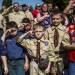 Eli Whalen, 10, center, purses his lip as he salutes the lives of fallen soldiers who have made the ultimate sacrifice dying for their country in battle while paying his respects alongside fellow Boy Scouts and Cub Scouts alike on Memorial Day amidst hundreds of families attending a ceremony on Monday, May 29, 2017 at Fairview Cemetery in Linden, Mich. (Jake May /The Flint Journal-MLive.com via AP)