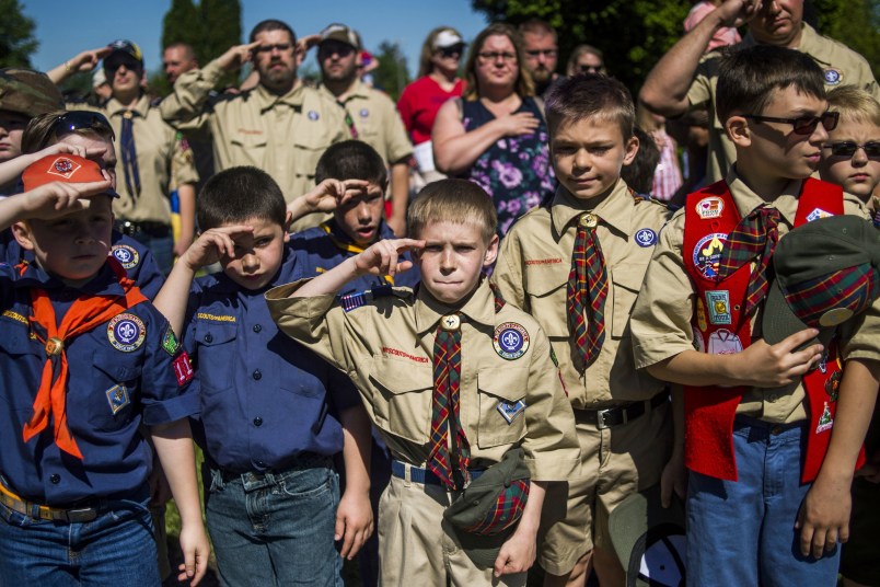 Eli Whalen, 10, center, purses his lip as he salutes the lives of fallen soldiers who have made the ultimate sacrifice dying for their country in battle while paying his respects alongside fellow Boy Scouts and Cub Scouts alike on Memorial Day amidst hundreds of families attending a ceremony on Monday, May 29, 2017 at Fairview Cemetery in Linden, Mich. (Jake May /The Flint Journal-MLive.com via AP)
