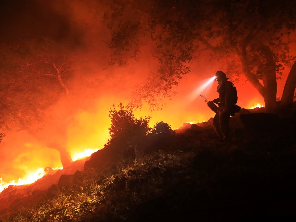 A San Diego Cal Fire firefighter monitors a flare up on a the head of the Nuns fire (the Southern LNU Complex), Wednesday Oct. 11, 2017 off of High Road above the Sonoma Valley.  A wind shift caused flames to move quickly up hill and threaten homes in the area.  (Kent Porter / Press Democrat) 2017