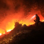 A San Diego Cal Fire firefighter monitors a flare up on a the head of the Nuns fire (the Southern LNU Complex), Wednesday Oct. 11, 2017 off of High Road above the Sonoma Valley.  A wind shift caused flames to move quickly up hill and threaten homes in the area.  (Kent Porter / Press Democrat) 2017