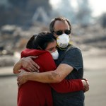 Howard Lasker, right, comforts his daughter, Gabrielle, who is visiting their home for the first time since a wildfire swept through it, Sunday, Oct. 15, 2017, in Santa Rosa, Calif. With the winds dying down, fire officials said Sunday they have apparently "turned a corner" against the wildfires that have devastated California wine country and other parts of the state over the past week, and thousands of people got the all-clear to return home. (AP Photo/Jae C. Hong)