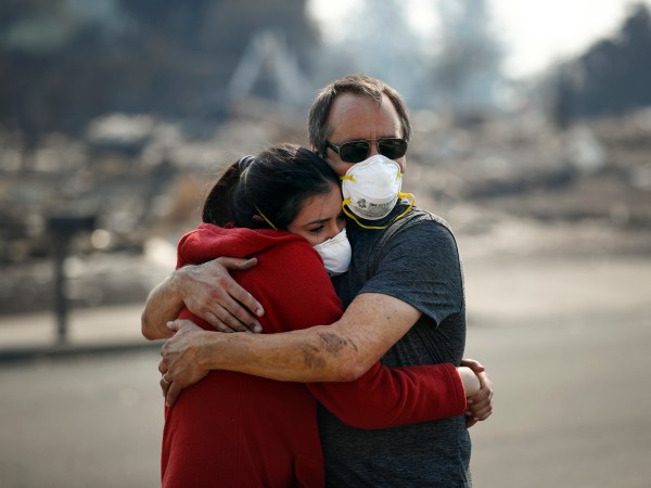 Howard Lasker, right, comforts his daughter, Gabrielle, who is visiting their home for the first time since a wildfire swept through it, Sunday, Oct. 15, 2017, in Santa Rosa, Calif. With the winds dying down, fire officials said Sunday they have apparently "turned a corner" against the wildfires that have devastated California wine country and other parts of the state over the past week, and thousands of people got the all-clear to return home. (AP Photo/Jae C. Hong)
