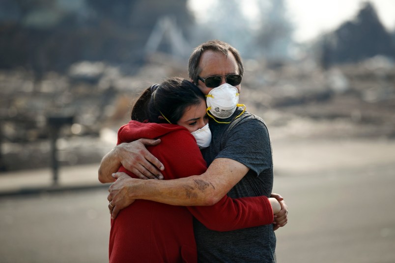 Howard Lasker, right, comforts his daughter, Gabrielle, who is visiting their home for the first time since a wildfire swept through it, Sunday, Oct. 15, 2017, in Santa Rosa, Calif. With the winds dying down, fire officials said Sunday they have apparently "turned a corner" against the wildfires that have devastated California wine country and other parts of the state over the past week, and thousands of people got the all-clear to return home. (AP Photo/Jae C. Hong)