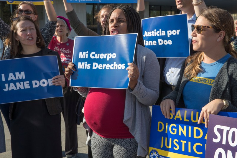 Activists with Planned Parenthood demonstrate in support of "Jane Doe," a pregnant 17-year-old being held in a Texas facility for unaccompanied immigrant children to obtain an abortion, outside of the Department of Health and Human Services in Washington, Friday, Oct. 20, 2017. (AP Photo/J. Scott Applewhite)