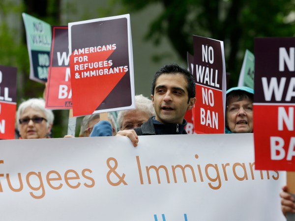 FILE--In this May 15, 2017, file photo, protesters hold signs during a demonstration against President Donald Trump's revised travel ban, Monday, May 15, 2017, outside a federal courthouse in Seattle. A three-judge panel of the 9th U.S. Circuit Court of Appeals on Monday upheld a decision to block the revised travel ban, which would suspend the nation's refugee program and temporarily bar new visas for citizens of Iran, Libya, Somalia, Sudan, Syria and Yemen. (AP Photo/Ted S. Warren, file)