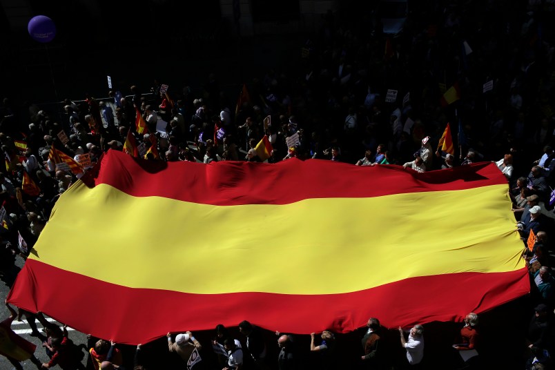 People hold a Spanish flag as they march during a protest the regional Catalan government's push to break away from the rest of Spain in Barcelona, Spain, Sunday, March 19, 2017. Several protesters carried Spanish flags and signs saying "Stop the Coup"  a reference to the regional government's plan to hold a referendum on independence, which Spain says is unconstitutional. (AP Photo/Manu Fernandez)