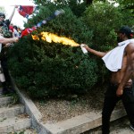 A counter demonstrator uses a lighted spray can against a white nationalist demonstrator at the entrance to Lee Park in Charlottesville, Va., Saturday, Aug. 12, 2017.   Gov. Terry McAuliffe declared a state of emergency and police dressed in riot gear ordered people to disperse after chaotic violent clashes between white nationalists and counter protestors. (AP Photo/Steve Helber)