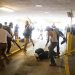 HFM for PM story**In this Saturday, Aug. 12, 2017 image provided by by Zach D. Roberts, Deandre Harris, bottom is assaulted in a parking garage beside the Charlottesville police station after a white nationalist rally was disbursed by police, in Charlottesville, Va. (Zach D. Roberts via AP)