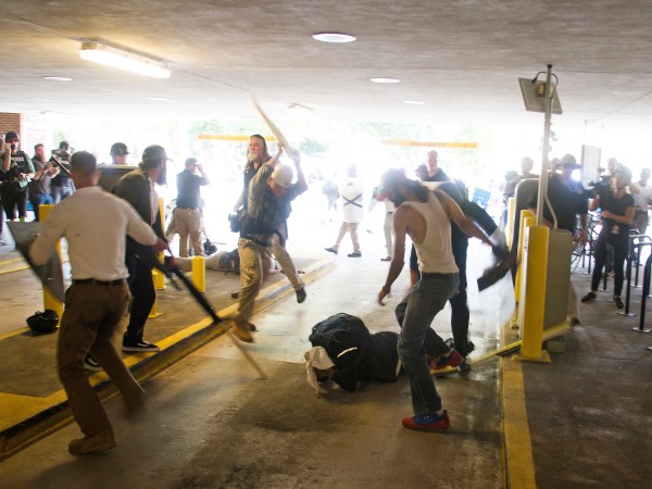 HFM for PM story**In this Saturday, Aug. 12, 2017 image provided by by Zach D. Roberts, Deandre Harris, bottom is assaulted in a parking garage beside the Charlottesville police station after a white nationalist rally was disbursed by police, in Charlottesville, Va. (Zach D. Roberts via AP)