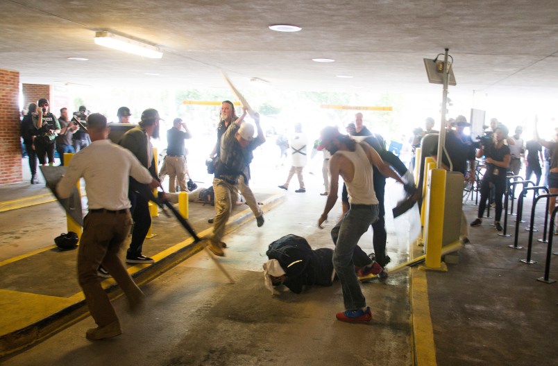 HFM for PM story**In this Saturday, Aug. 12, 2017 image provided by by Zach D. Roberts, Deandre Harris, bottom is assaulted in a parking garage beside the Charlottesville police station after a white nationalist rally was disbursed by police, in Charlottesville, Va. (Zach D. Roberts via AP)