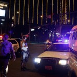 Police officers stand along the Las Vegas Strip the Mandalay Bay resort and casino during a shooting near the casino, Sunday, Oct. 1, 2017, in Las Vegas. (AP Photo/John Locher)