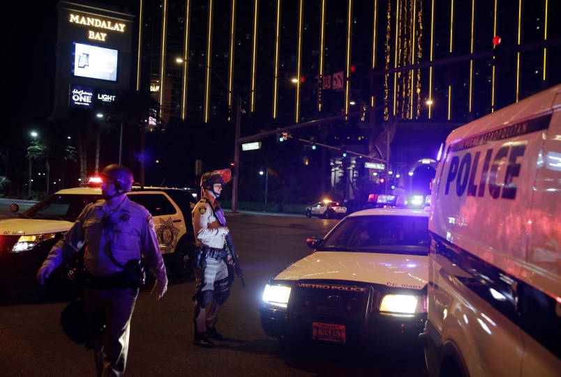 Police officers stand along the Las Vegas Strip the Mandalay Bay resort and casino during a shooting near the casino, Sunday, Oct. 1, 2017, in Las Vegas. (AP Photo/John Locher)
