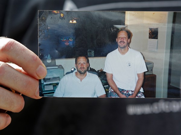 Eric Paddock, brother of  Las Vegas gunman Stephen Craig Paddock, holds up a photo of he and his brother outside his home, Monday, Oct. 2, 2017, in Orlando, Fla. Eric Paddock is on the left. (AP Photo/John Raoux)