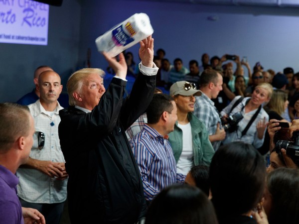 President Donald Trump tosses paper towels into a crowd as he hands out supplies at Calvary Chapel, Tuesday, Oct. 3, 2017, in Guaynabo, Puerto Rico. (AP Photo/Evan Vucci)