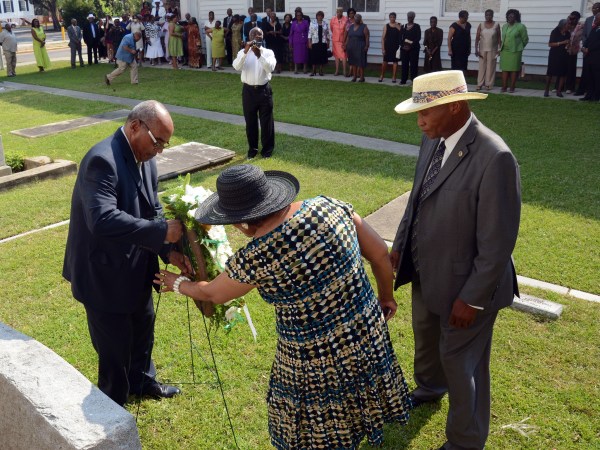 In this Sunday, July 1, 2012, photo, from left, Freddie Meyer, great-great grandson of Robert Smalls, places a wreath in front of Smalls' grave with help from fellow descendant Carolyn Meyer-Little and Edgar Williams, one of the Robert Smalls Association reunion organizers, during the reunion near Tabernacle Baptist Church in Beaufort, S.C. Robert Smalls was an African American slave during and after the Civil War, who freed himself, his crew and their families by commandeering a Confederate transport ship, the CSS Planter, and sailing it to freedom. (AP Photo/The Beaufort Gazette, Sarah Welliver)