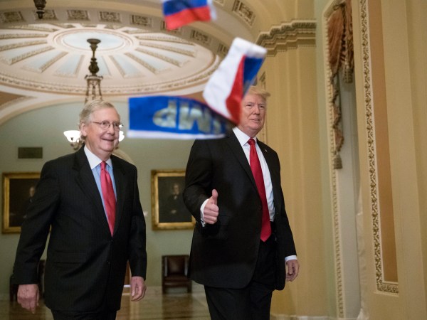 Small Russian flags are thrown by a protester as President Donald Trump, escorted by Senate Majority Leader Mitch McConnell, R-Ky., arrives on Capitol Hill to have lunch with Senate Republicans and push for his tax reform agenda, in Washington, Tuesday, Oct. 24, 2017. (AP Photo/J. Scott Applewhite)