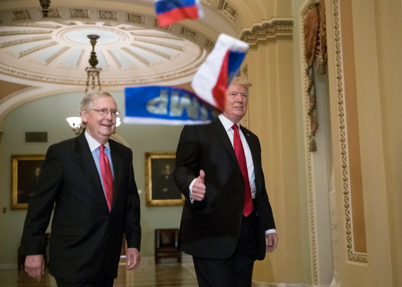 Small Russian flags are thrown by a protester as President Donald Trump, escorted by Senate Majority Leader Mitch McConnell, R-Ky., arrives on Capitol Hill to have lunch with Senate Republicans and push for his tax reform agenda, in Washington, Tuesday, Oct. 24, 2017. (AP Photo/J. Scott Applewhite)