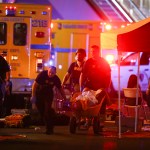 A wounded person is walked in on a wheelbarrow as Las Vegas police respond during an active shooter situation on the Las Vegas Stirp in Las Vegas  Sunday, Oct. 1, 2017. Multiple victims were being transported to hospitals after a shooting late Sunday at a music festival on the Las Vegas Strip. (Chase Stevens/Las Vegas Review-Journal via AP)