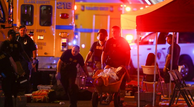 A wounded person is walked in on a wheelbarrow as Las Vegas police respond during an active shooter situation on the Las Vegas Stirp in Las Vegas  Sunday, Oct. 1, 2017. Multiple victims were being transported to hospitals after a shooting late Sunday at a music festival on the Las Vegas Strip. (Chase Stevens/Las Vegas Review-Journal via AP)