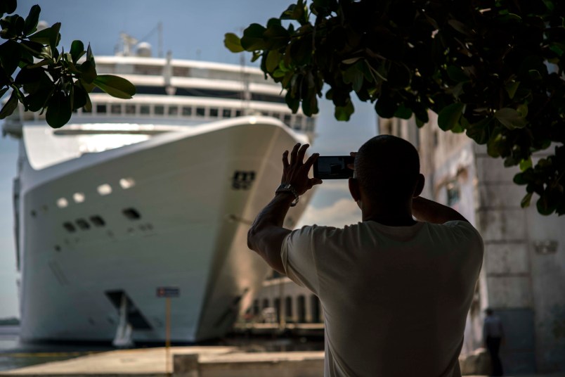 A man takes a photo with his phone to a cruise in Havana, Cuba,Saturday, June 17, 2017. President Trump declared he was restoring some travel and economic restrictions on Cuba that were lifted as part of the Obama administration's historic easing.(AP Photo/Ramon Espinosa)