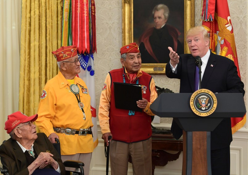 President Donald Trump, right, speaks during a meeting with Navajo Code Talkers including Thomas Begay, second from left, and Peter MacDonald, second from right, in the Oval Office of the White House in Washington, Monday, Nov. 27, 2017. (AP Photo/Susan Walsh)