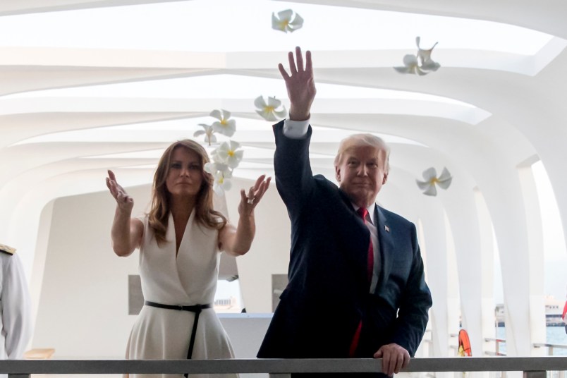 President Donald Trump and first lady Melania Trump throw flower pedals while visiting the Pearl Harbor Memorial, Friday, November 3, 2017, in Honolulu, Hawaii. Trump begins a 5 country trip through Asia traveling to Japan, South Korea, China, Vietnam and the Philippians. (AP Photo/Andrew Harnik)