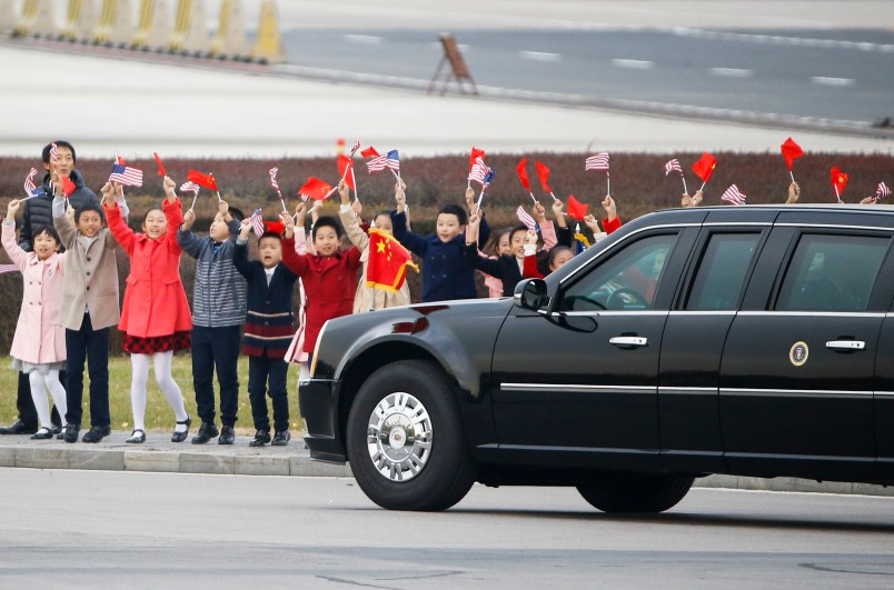 Children wave to the car carrying U.S. President Donald Trump and first lady Melania after their arrival at Beijing airport, China, November 8, 2017. REUTERS/Thomas Peter