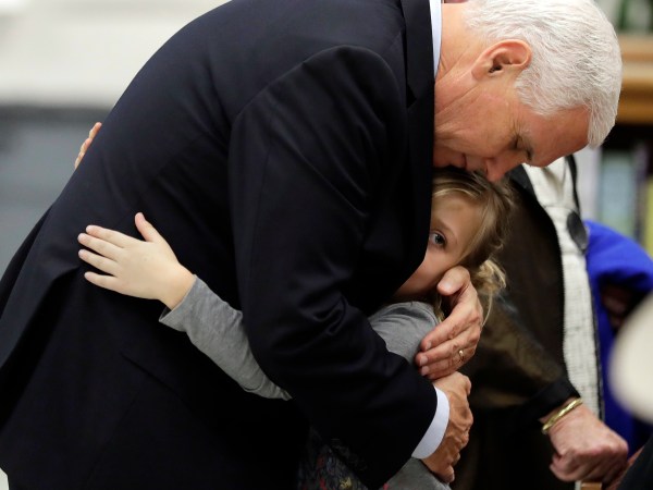 Vice President Mike Pence hugs Evelyn Holcombe at Florseville High School during a stop, Wednesday, Nov. 8, 2017, in Floresville, Texas.  A man opened fire inside the church in the small South Texas community on Sunday, killing and wounding many; Hiolcombe was in the church during the shooting but escaped. (AP Photo/Eric Gay)