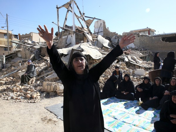 A woman moans on the earthquake site in Sarpol-e-Zahab in western Iran, Tuesday, Nov. 14, 2017. Rescuers are digging through the debris of buildings felled by the Sunday earthquake that killed more than four hundred people in the border region of Iran and Iraq. (AP Photo/Vahid Salemi)