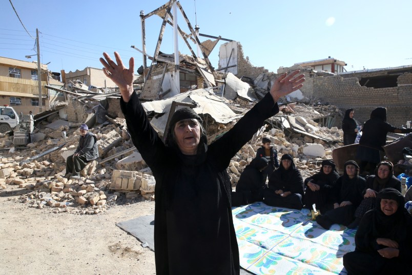 A woman moans on the earthquake site in Sarpol-e-Zahab in western Iran, Tuesday, Nov. 14, 2017. Rescuers are digging through the debris of buildings felled by the Sunday earthquake that killed more than four hundred people in the border region of Iran and Iraq. (AP Photo/Vahid Salemi)
