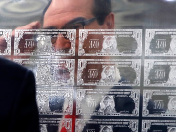 Treasury Secretary Steven Mnuchin is reflected in a printing plate of $1 notes bearing his signature, Wednesday, Nov. 15, 2017, at the Bureau of Engraving and Printing in Washington. The new series of 2017, 50-subject $1 notes, will be sent to the Federal Reserve to issue into circulation. (AP Photo/Jacquelyn Martin)