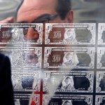 Treasury Secretary Steven Mnuchin is reflected in a printing plate of $1 notes bearing his signature, Wednesday, Nov. 15, 2017, at the Bureau of Engraving and Printing in Washington. The new series of 2017, 50-subject $1 notes, will be sent to the Federal Reserve to issue into circulation. (AP Photo/Jacquelyn Martin)