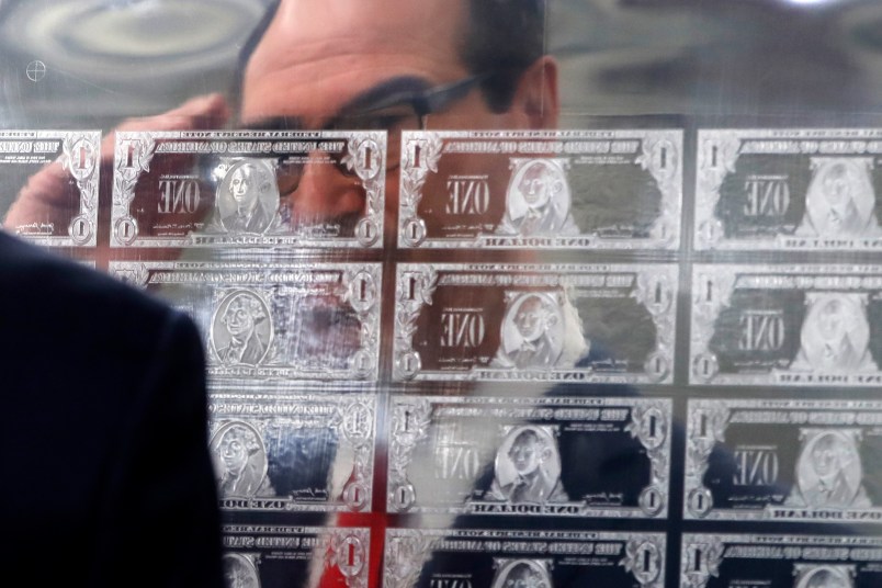 Treasury Secretary Steven Mnuchin is reflected in a printing plate of $1 notes bearing his signature, Wednesday, Nov. 15, 2017, at the Bureau of Engraving and Printing in Washington. The new series of 2017, 50-subject $1 notes, will be sent to the Federal Reserve to issue into circulation. (AP Photo/Jacquelyn Martin)