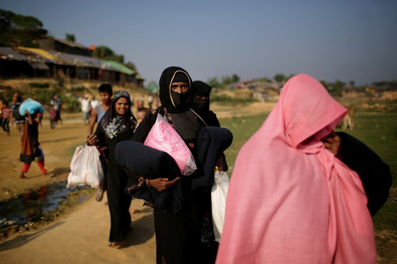 Rohingya Muslim women carry blankets and other supplies they collected from aid distribution centers on Tuesday, Nov. 21, 2017, in Kutupalong refugee camp in Bangladesh. Since late August, more than 620,000 Rohingya have fled Myanmar's Rakhine state into neighboring Bangladesh, seeking safety from what the military described as "clearance operations." The United Nations and others have said the military's actions appeared to be a campaign of "ethnic cleansing," using acts of violence and intimidation and burning down homes to force the Rohingya to leave their communities. (AP Photo/Wong Maye-E)