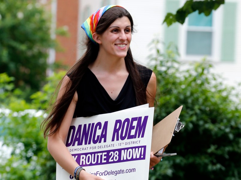 Democratic nominee for the House of Delegates 13th district seat, Danica Roem, brings campaign signs as she greets voters while canvasing a neighborhood Wednesday, June 21, 2017, in Manassas, Va. Roem is running against Del. Bob Marshall in the 13th House of Delegates District. (AP Photo/Steve Helber)